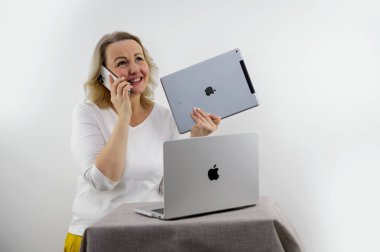 Kadın, Apple 'dan hediye olarak çeşitli aletler iPad Macbook iPhone 13 Pro Max' ten beyaz arka planda orta yaşlı sarışın dans eden yeni metin teknolojileri için yer açmaktan mutluluk duyuyor.