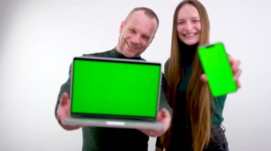 Lovers are happy to consider new purchases advertising gadgets in the store a guy and a girl a man and a girl young family chasing a man and daughter show the purchased goods sales managers