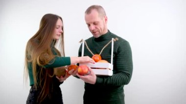 middle-aged man seller offers girl to buy fruits tangerine apple Coconut evaluating listens to seller meat-eater listens to vegan seller balding man in market offers girl to buy fruits exotic fruits