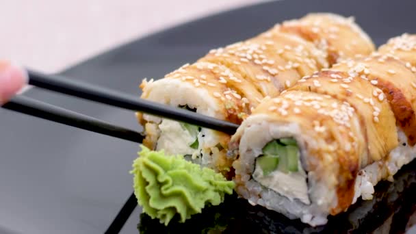 Evőpálcikák Szusit Eszkolárral Válogatott Sushi Ból Fekete Tányéron Sötét Háttérrel — Stock videók