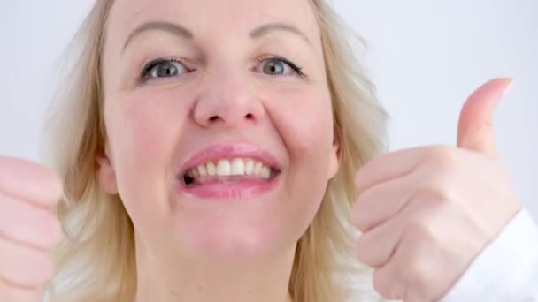 Ευτυχισμένη Γυναίκα Χαμογελάει Δείχνει Τους Αντίχειρες Ψηλά Φορώντας Ένα Λευκό — Αρχείο Βίντεο