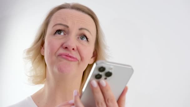 携帯電話の画面を見て ストレスを受けた神経の女性は 悪いニュースでメッセージや電子メールを受け取ることに不満を感じている 不幸な千年の女性ユーザーは悪い電子機器の仕事に不満 — ストック動画