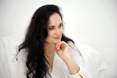 Yakından. Beyaz kazaklı güzel bir kadın kameranın önünde poz veriyor. Yüksek kalite fotoğraf