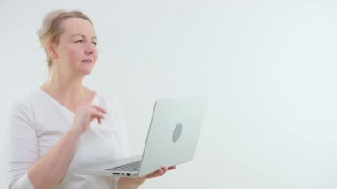 Beyaz arka planda kıvırcık saçlı bir kadın dizüstü bilgisayardaki problemleri çözüyor. Telefona cevap veriyor. Telefonlara cevap veriyor. Memnuniyetsizlik.