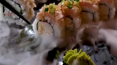 Lezzetli bir restoranda Asya yemeği suşisi tabağında kuru buz dekorasyonu restoranı taştan tabakta lezzetli ton balığı seti ve uzay metni reklamının her yerinde akan beyaz dumanla servis ediliyor.