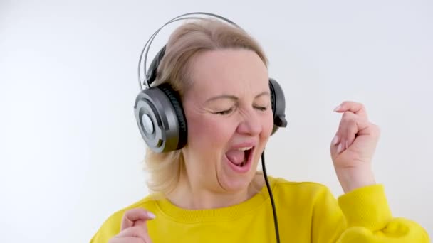 ヘッドフォンを持つ女性は青の背景に隔離された音楽を聴く パーティー ライフスタイル ラジオ ディスコのコンセプト コピースペース 高品質4K映像 — ストック動画