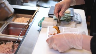 Şef suşi sashimi nigiri yapıyor. Master sınıfı. Profesyonel şef suşi yapmayı öğretiyor. Japon yemek hazırlama süreci. Ellerinde yemek tutarak. Yüksek kalite 4k görüntü