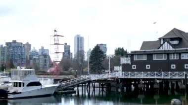 4k Güzel liman, liman, marina, liman, yelkenli tekneler, yatlar, mavi su, göl, körfez, ağaçlar, park, ev, rıhtım, sakin, güneşli bir gün. Yüksek kalite 4k görüntü