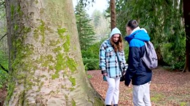 Stanley Park gençleri yürürken fotoğraf çekiyorlar. Ağaçlara bakıyorlar. Güz baharı muhabbetlerine bakıyorlar.
