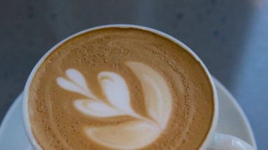 Beyaz kapuçino kahve fincanında ağaç desenli bir fincan kahve, latte sanatıyla izole edilmiş. Yüksek kalite fotoğraf