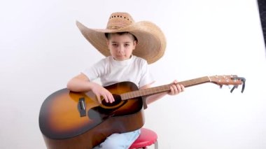 Gitar çalan sevimli çocuk parmaklarını kapat. Çocuklar için müzik okulu. Müzik akorları. Yüksek kalite 4k görüntü
