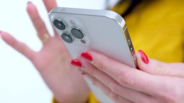 Kanepede oturan telefonu kullanan genç bir kadın. Akıllı telefonla mesaj yazan kişiyi kapat. Yüksek kalite 4k görüntü
