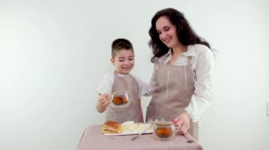 Anne ve oğul çay içip çörek ve kruvasan yiyorlar. Yüksek kalite 4k görüntü