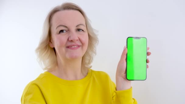 Усміхнена Зріла Жінка Позує Тримаючи Телефон Точками Стеження Порожньому Порожньому — стокове відео