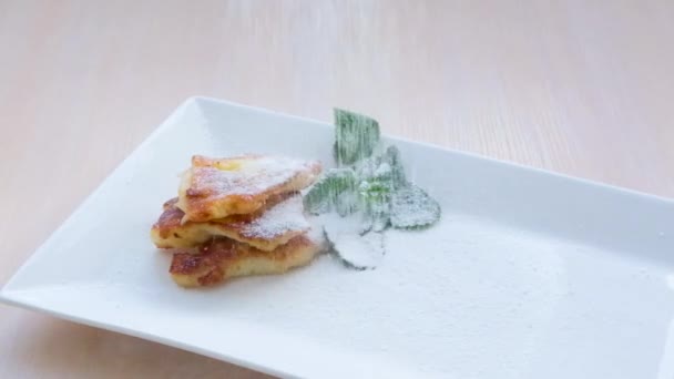 粉砂糖でパンケーキを振りかける 朝食のチーズケーキは粉砂糖を振りかけた 高品質のフルHd映像 — ストック動画