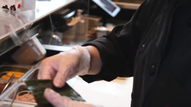 寿司職人の手を閉じて日本料理を準備する レストランで寿司を作る男 伝統的なアジアのロールはまな板に ベジタリアン巻き寿司 高品質4K映像 — ストック動画