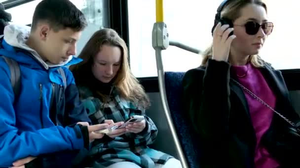 青い服の2人のティーネージャーがバスに座っていますカナダバンクーバーフード秋の冬の春のトラックスーツは 位置情報旅行旅行者のための携帯電話検索を使用現実の生活 — ストック動画