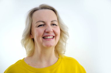 Yetişkin bir kadının yavaş çekimde çekilmiş portresi, iyimser, kaygısız, canlı tavrı ve parlak beyaz dişleri ile gülümsüyor. Mutlu ruh hali, ağız sağlığı, diş bakımı kavramı. Yüksek kalite