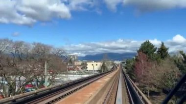 Trenin ön camından ateş ediyor, köprülerin altından geçiyor, binanın ve tüm demiryolunun arabalarını görebilirsiniz ağır çekimde kimse yok Surrey Vancouver Canada 2023