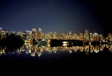 Vancouver şehir merkezinde bir kış akşamı alacakaranlıkta görkemli dağların önünde parlıyor. Yüksek kalite fotoğraf