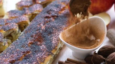 Arkaplanda tarçınlı turta serpiştirilmiş küçük bir fincana serpiştirilmiş tarçınlı tarçınlı turta.