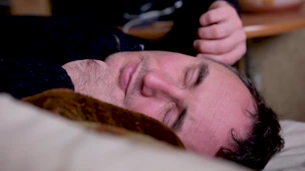 男人穿着衣服睡在床上把自己拉起来擦擦他的眼睛睁开眼睛想醒来或睡着累坏了的男人躺在床上睡着了 — 图库视频影像