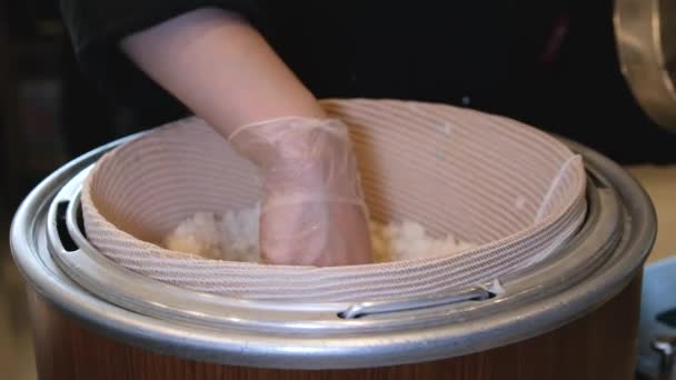 アジア料理店でおいしい寿司のためにご飯を調理するシェフ クックは寿司飯の上に塩辛い生のサーモンのスライスを置きます 寿司を魚や米の材料で調理する — ストック動画