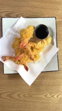 Bir porsiyon karides tempura sosuyla süslenmiş, kızarmış karides tabağına yakından bakın. Restoran yemeği, gurme yemekleri ve hareket konsepti. Yüksek kalite