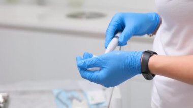Diş kliniklerindeki akıllı saatlerden eldivenli doktor kız kardeşlerin elleri suyun geldiği sulayıcıyı ayarlamaya çalışıyor ya da su peçeteye yakın çekim diş hekiminin dişçisine gitmiyor