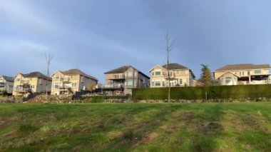 Özel sektör manzarası Yüksek bir tepe, mavi gökyüzü ve yeşil çimen yarılanma alanı zengin özdeş üç katlı evler için Surrey Vancouver Kanada 2023