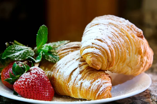 closeup delicious appetizing fresh crunchy croissants sprinkled with powdered sugar on marble table white plate tasty food lunch snack porous structure baking diet place ad menu french breakfast
