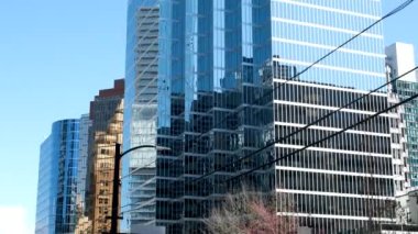 Burrard İstasyonu 'ndaki ofis binaları çalışanları tramvay trafik ışıklarına doğru koşuşturuyor. Erkekler ve kadınlar caddeyi geçerek toplu taşıma şehrine giderler. Kanada Vancouver 12.04.2023