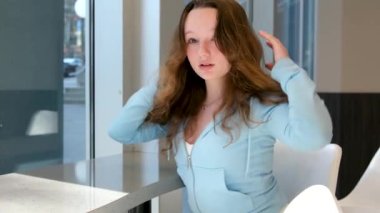 Ofisteki güzel kız, saç özel okul çalışmasını düzeltiyor. Mükemmel bir öğrenci olmak için mükemmel hassas ergenlik güzelliği. Beyaz yüzlü, mavi saçlı, Avrupalı Ukraynalı.