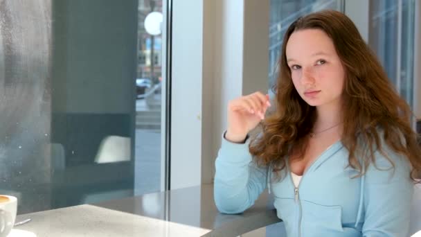 Tonårsflicka Sitter Omtänksam Vid Fönstret Dagdrömmande Skickar Kyss Och Börjar — Stockvideo