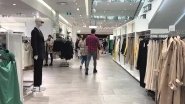 Genç kız kıyafet alışverişi yapıyor ve moda kadını için yeni kıyafet seçiyor. Alışveriş yaparken iyi görünmek istiyor. Gençlik alışveriş sinirleri.