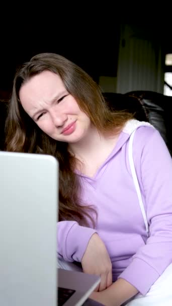 不満を持つ少女は彼女の両親とノートパソコンで話して目をねじ込み彼女は彼らが言うことが好きではありません従うことを望んでいませんLilacブラウス思春期ロール彼女の目の不快感 — ストック動画