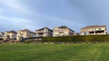 Özel sektör manzarası Yüksek bir tepe, mavi gökyüzü ve yeşil çimen yarılanma alanı zengin özdeş üç katlı evler için Surrey Vancouver Kanada 2023
