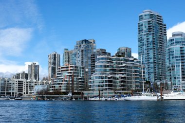 Alçaktan uçarak, Granville Adası Yaletown Limanı 'nın üzerinden geçeceğiz. Kayıkçılar, park halindeki yatları yüzerek taşıyacak. 