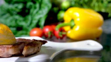 Bıçak ve çatalla sulu ızgara fileto dilimleme bıçak ve çatalla kesme lezzetli ızgara wagyu bifteği rosto tabakta taze sebze ve kızarmış et bir parça biftek buharı kesme