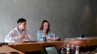 Genç erkekler, genç kızlar, restoranda suşi yerler. Lezzetli Asya yemekleri. İlk buluşmada çocuklarla iletişim kurarlar.