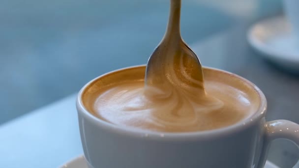 古い木製の背景にハートとコーヒー豆の形のコーヒーラテのカップ食べる泡または厚い泡熱いコーヒーの泡朝のオーバーヘッドでミルクフォームとカプチーノコーヒーのラテ大規模なカップ — ストック動画