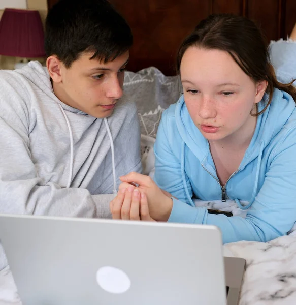 stock image online learning teenagers boy and girl sitting near laptop and doing homework watching movie friends Classmates bedroom bed smile like each other First love bright room friends spend time together