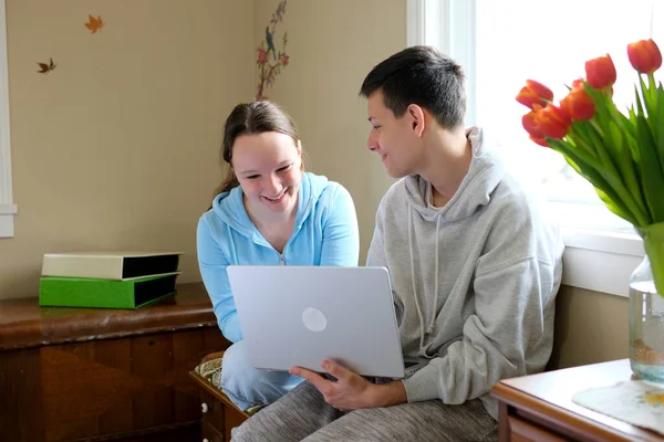 Çevrimiçi öğrenim gören gençler dizüstü bilgisayar başında oturup film seyrediyorlar sınıf arkadaşları yatak odası arkadaşları birbirleri gibi gülümsüyor ilk aşk odası arkadaşları birlikte vakit geçiriyorlar