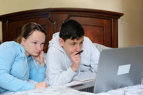 Çevrimiçi öğrenim gören gençler dizüstü bilgisayar başında oturup film seyrediyorlar sınıf arkadaşları yatak odası arkadaşları birbirleri gibi gülümsüyor ilk aşk odası arkadaşları birlikte vakit geçiriyorlar