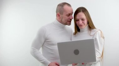 Dizüstü bilgisayar kullanan bir çift internetten kıyafet seçiyor, seyahat turu planı seçiyor. Birlikte alışveriş yapmak, evde teslimat yapmak, uzaktan satın alma konsepti.