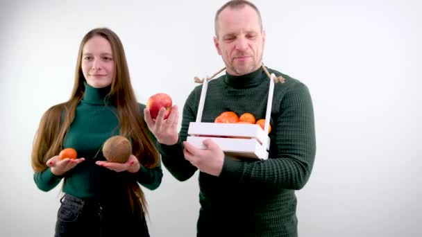 Mann Selger Frukt Jente Holder Kokosnøtt Tangeriner Nær Brystet Veiing – stockvideo