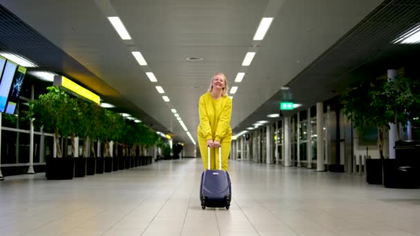 黄色のスーツケースを手にスーツケースを持って空港に到着または出発電話の会話を保持する黄色のスーツケースに荷物を持って — ストック動画