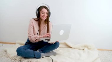 İnternette çalışan dizüstü bilgisayarda yazan genç bir iş kadını, bilgisayar teknolojisi kullanan güzel bir kadın profesyonel kullanıcı ya da internet üzerinden iş yapan ya da ev kulaklığı takan bir internet sitesi olan bir kadın.
