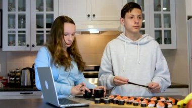 Dizüstü bilgisayarlarda film izleyip eğlenen genç erkekler ve kızlar mutfakta suşi yiyorlar. Fast food dağıtıyorlar. Eğlenceli ilişkiler, eğlenceli ilişkiler.