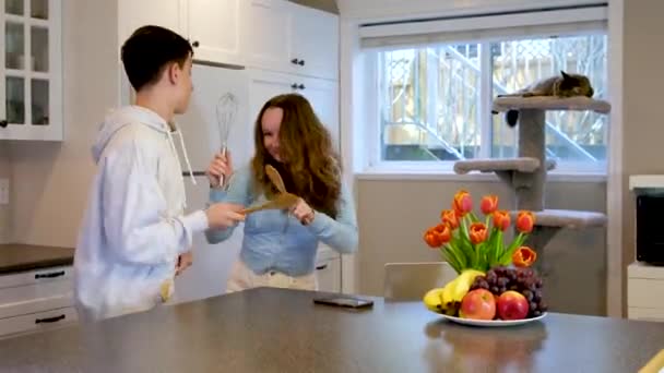 有趣的快乐家庭的年轻人喜欢跳舞 一起跳厨房做饭 快乐的男孩和女孩与在家里准备健康饭菜的未成年女孩一起玩乐 — 图库视频影像